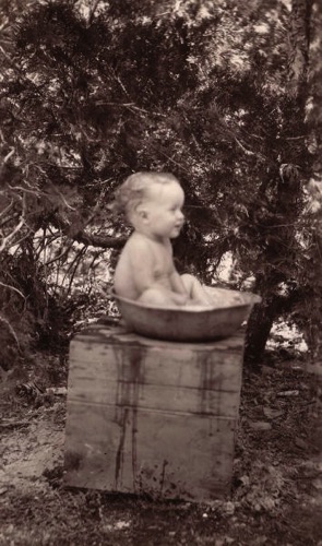 Allan Knotts, Christopher Lynch's great-grandson, having a basin bath at Petersen's cabin - 1934